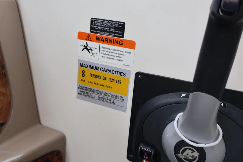 Slide: The Image of Warning and capacity labels on 2006 Larson Cabrio 240 boat dashboard. - 43