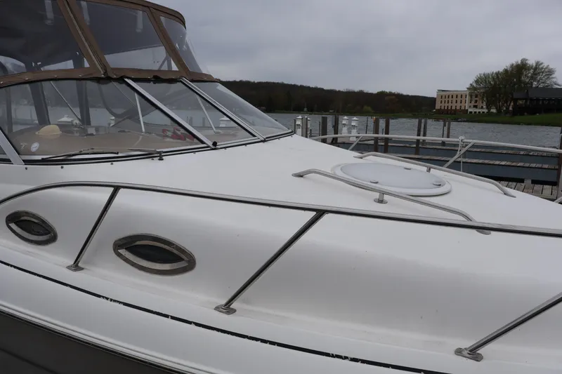 Slide: The Image of 2006 Larson Cabrio 240 boat docked by a lake on a cloudy day. - 50
