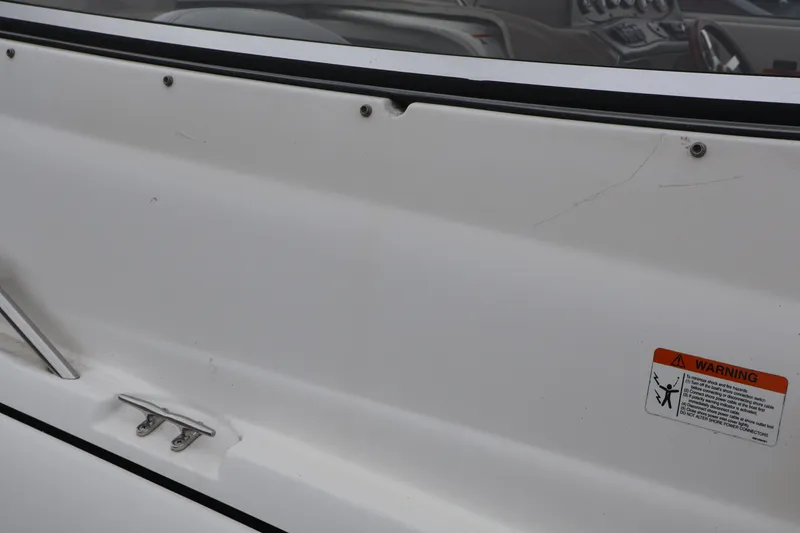 Slide: The Image of 2006 Larson Cabrio 240 boat interior with warning label and dashboard view. - 53