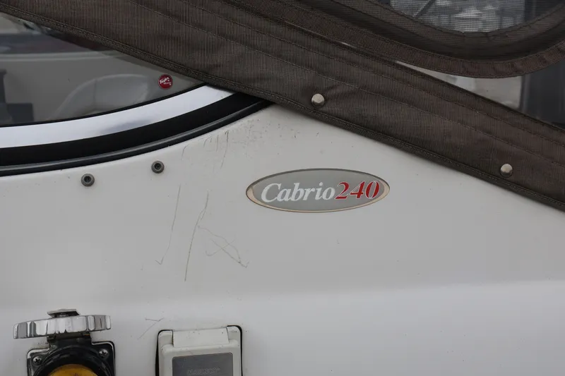 Slide: The Image of 2006 Larson Cabrio 240 boat exterior with logo and canvas cover. - 54