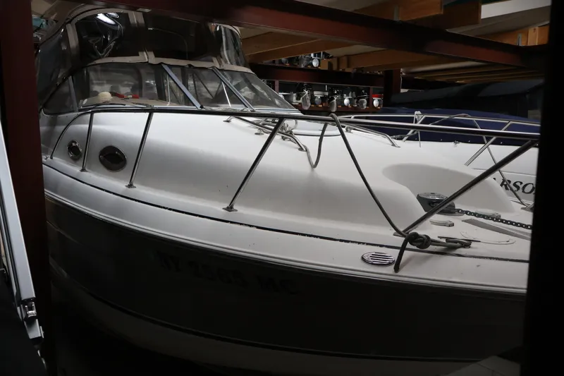 Slide: The Image of 2006 Larson Cabrio 240 boat stored indoors, showcasing sleek design and sturdy build. - 7