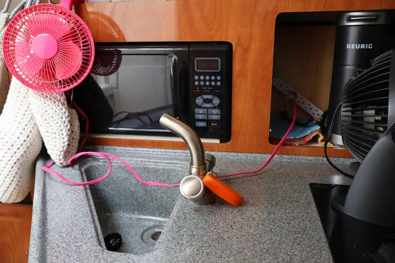 Slide: The Image of 2006 Larson Cabrio 240 kitchen area with sink, microwave, and appliances. - 8