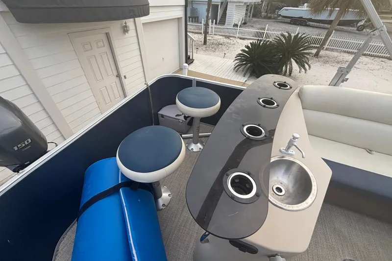 Slide: The Image of 2018 Godfrey Sweetwater 2486 C boat interior with bar stools, sink, and cup holders. - 3