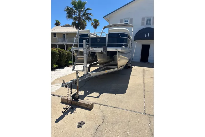 Slide: The Image of 2018 Godfrey Sweetwater 2486 C pontoon boat on trailer, parked in driveway. - 4