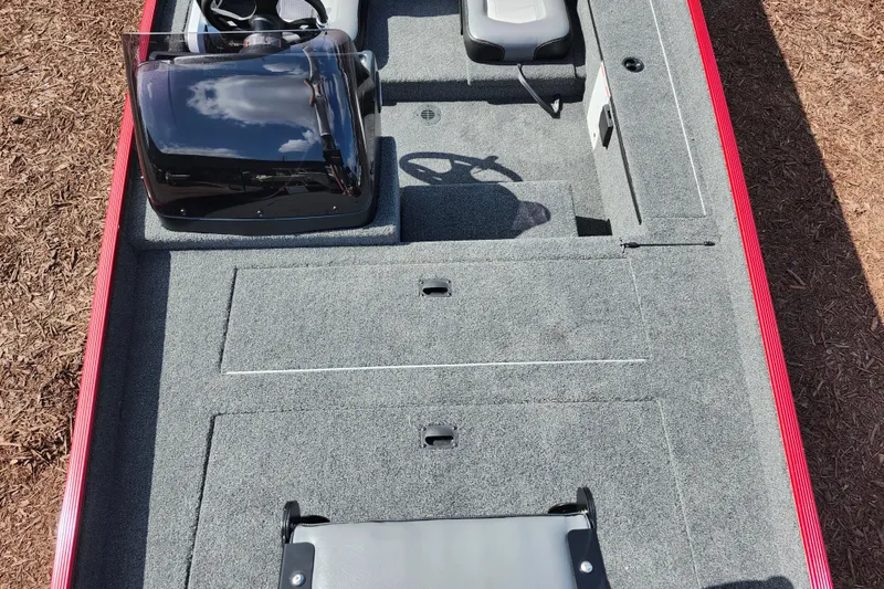 Slide: The Image of 2026 Lowe Skorpion 17 boat interior with steering console and seating, featuring gray carpeting. - 11