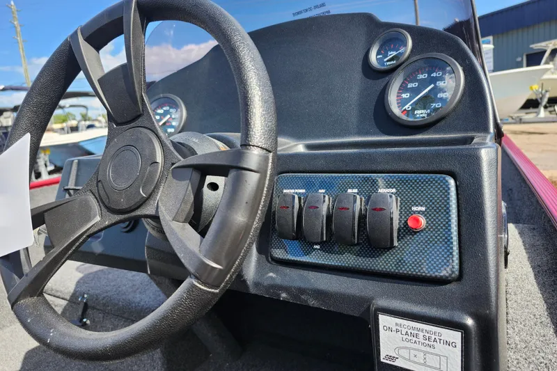 Slide: The Image of Steering wheel and dashboard of 2026 Lowe Skorpion 17 boat, featuring gauges and switches. - 14