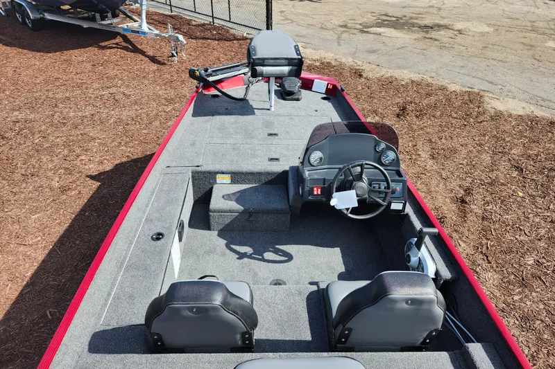 Slide: The Image of 2026 Lowe Skorpion 17 boat interior with steering console and seating, displayed outdoors. - 16