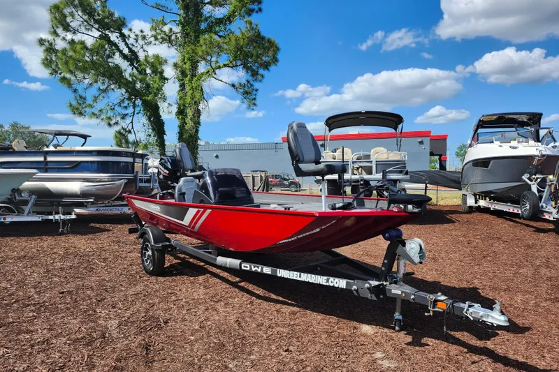Slide: The Image of 2026 Lowe Skorpion 17 boat in vibrant red, displayed outdoors on a trailer. - 2