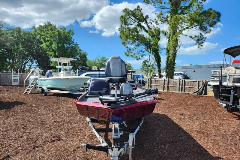Slide: The Image of 2026 Lowe Skorpion 17 boat on trailer in outdoor lot, surrounded by trees and other boats. - 3