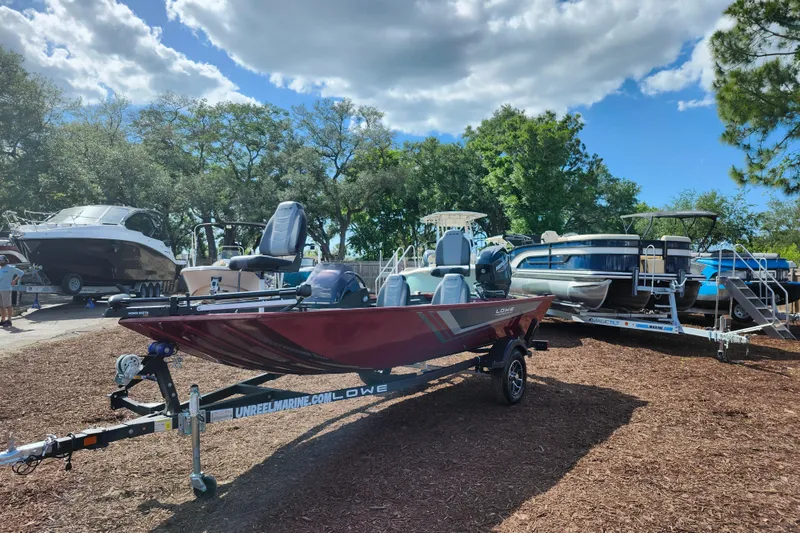 Slide: The Image of 2026 Lowe Skorpion 17 boat on trailer, surrounded by other boats, under a partly cloudy sky. - 4