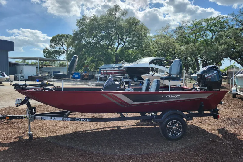 Slide: The Image of 2026 Lowe Skorpion 17 boat on trailer, red exterior, parked outdoors under cloudy sky. - 5