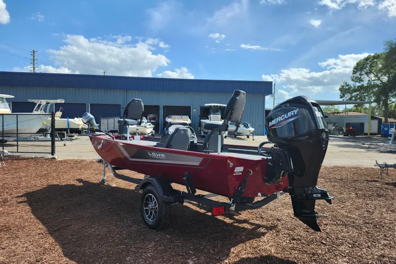 Slide: The Image of 2026 Lowe Skorpion 17 boat with Mercury engine, parked outdoors under a clear blue sky. - 6