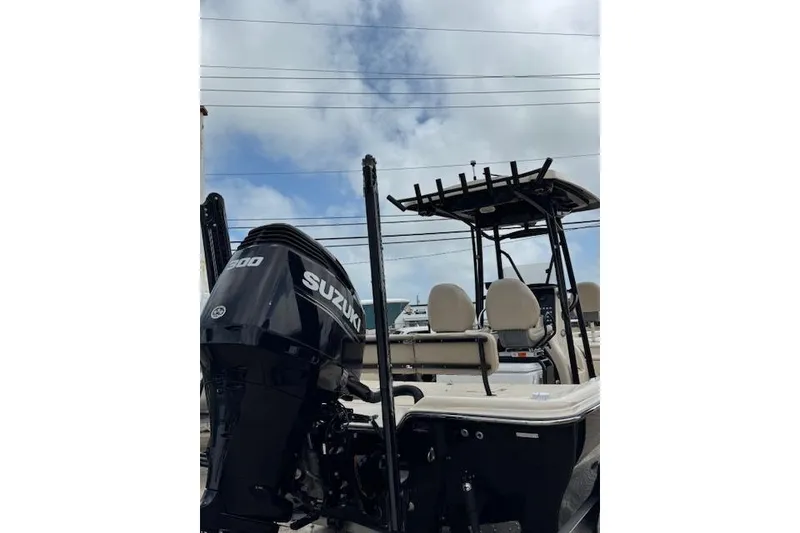 Slide: The Image of 2019 Blue Wave 2400 PureBay boat with Suzuki engine, viewed from the rear under cloudy sky. - 13