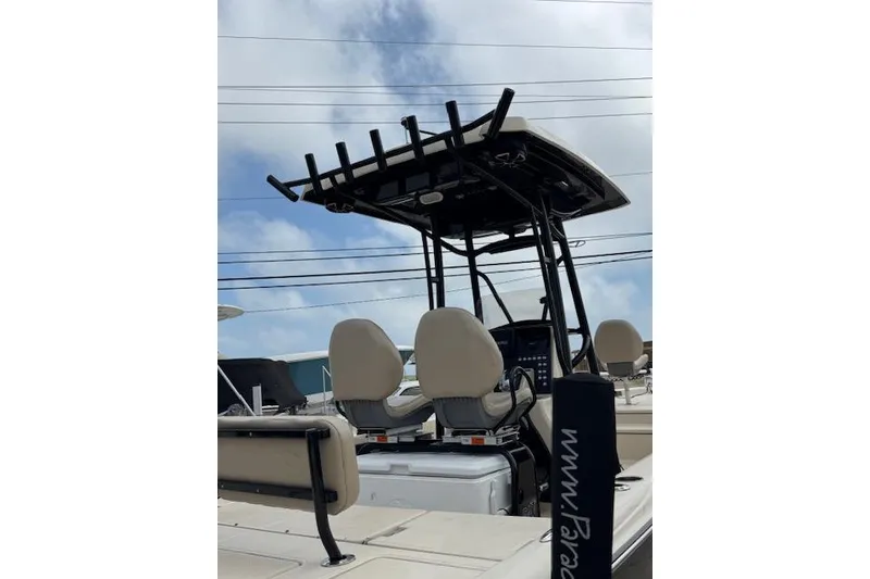 Slide: The Image of 2019 Blue Wave 2400 PureBay boat with dual seats and T-top under a cloudy sky. - 14
