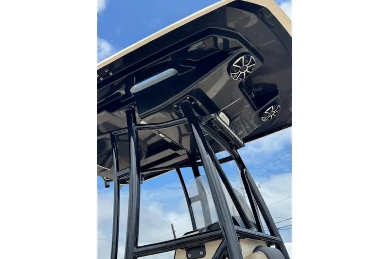 Slide: The Image of 2019 Blue Wave 2400 PureBay boat T-top with speakers against a blue sky. - 18