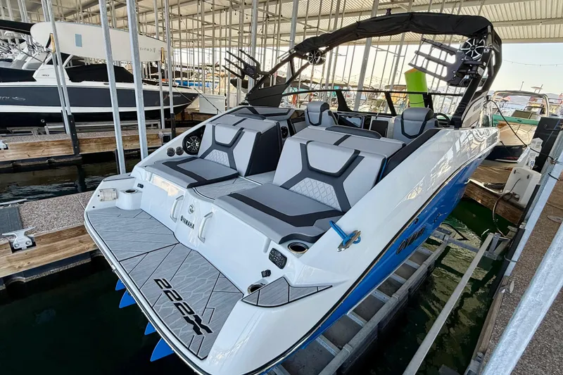 Slide: The Image of 2024 Yamaha Boats 222XE in marina, showcasing sleek design and modern seating. - 1