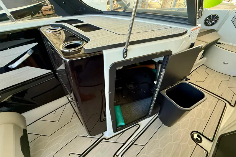 Slide: The Image of 2024 Yamaha Boats 222XE interior with storage compartment and cup holders. - 12