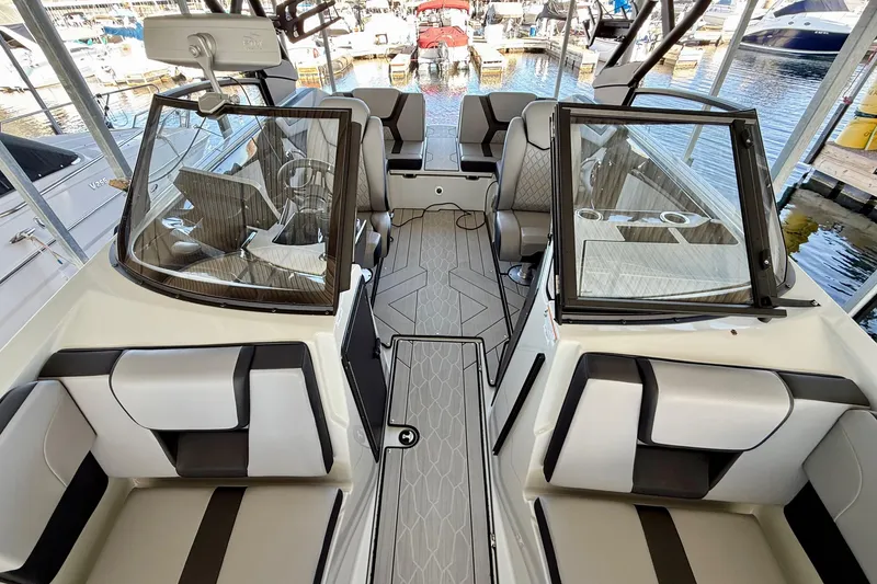 Slide: The Image of 2024 Yamaha Boats 222XE interior with modern seating and sleek design at a marina. - 13