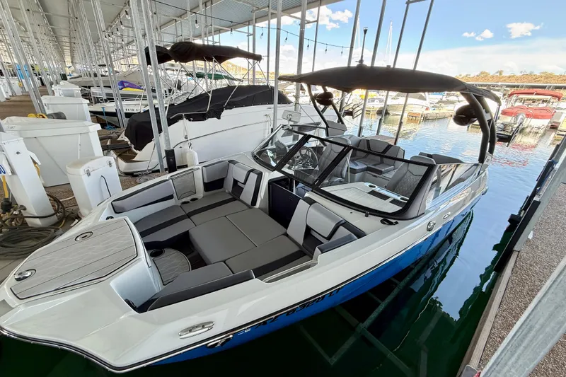 Slide: The Image of 2024 Yamaha Boats 222XE docked in a marina, showcasing sleek design and spacious seating. - 19