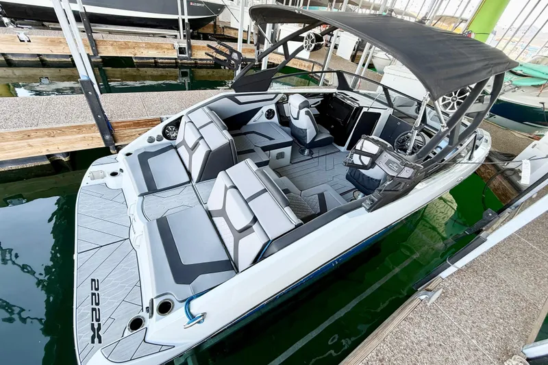 Slide: The Image of 2024 Yamaha Boats 222XE with sleek interior and canopy docked at marina. - 20