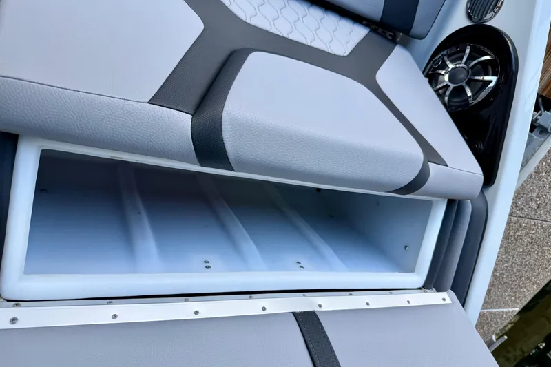 Slide: The Image of 2024 Yamaha Boats 222XE storage compartment with sleek seating and speaker detail. - 24