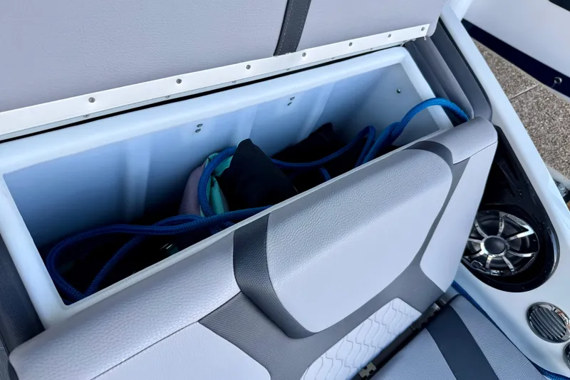 Slide: The Image of 2024 Yamaha Boats 222XE storage compartment with speaker and accessories. - 25