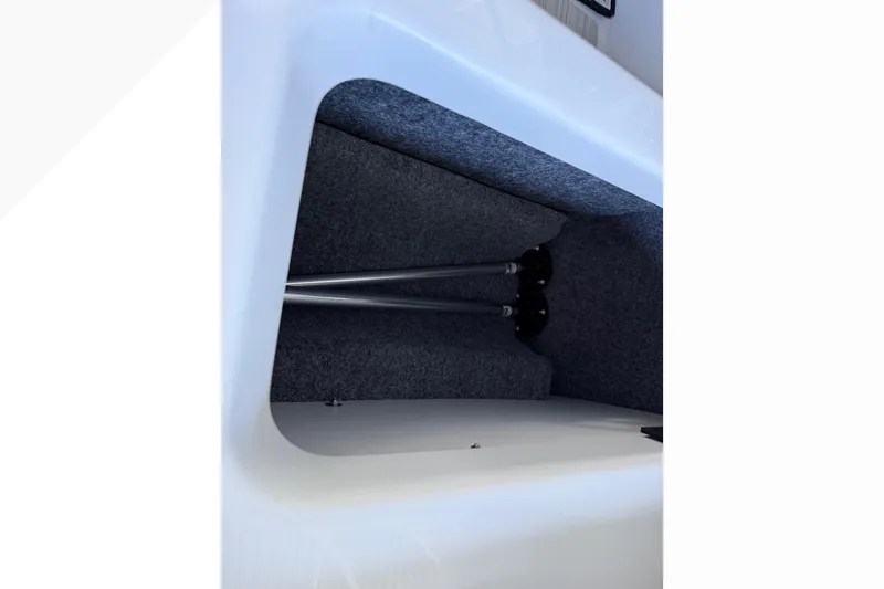 Slide: The Image of Storage compartment in 2024 Yamaha Boats 222XE, featuring carpeted interior and metal supports. - 27