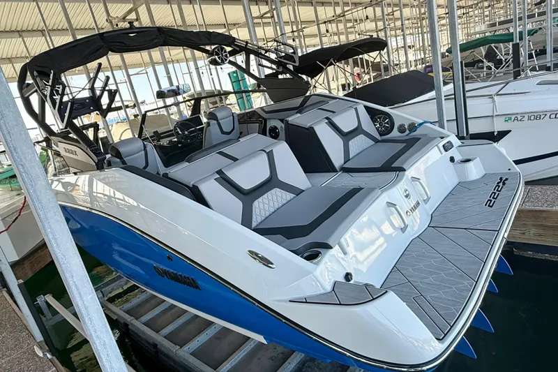 Slide: The Image of 2024 Yamaha Boats 222XE in marina, showcasing sleek design and spacious seating. - 6