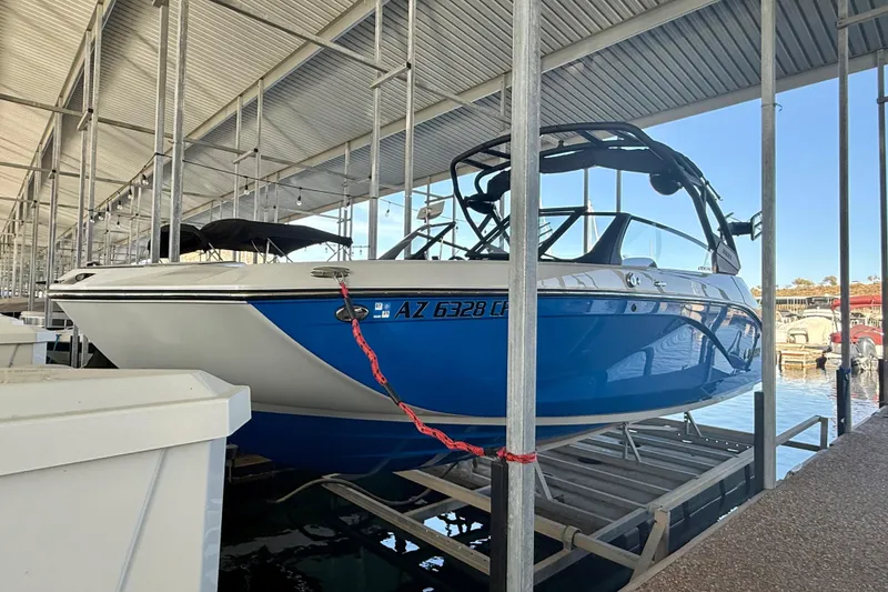 Slide: The Image of 2024 Yamaha Boats 222XE in a marina, featuring a sleek blue and white design. - 7