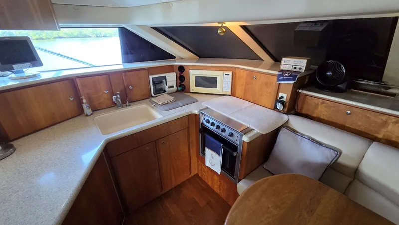 Slide: The Image of Interior of 2001 Silverton 453 yacht featuring kitchen and seating area. - 36