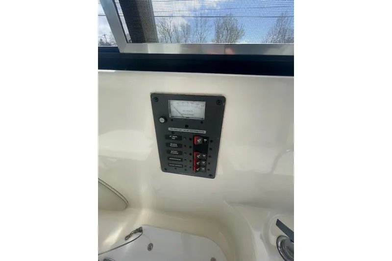 Slide: The Image of Control panel inside a 2006 Trophy 2359 Hardtop boat, featuring switches and a gauge. - 10