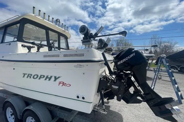 Slide: The Image of 2006 Trophy 2359 Hardtop boat with Mercury outboard motor on trailer under blue sky. - 17