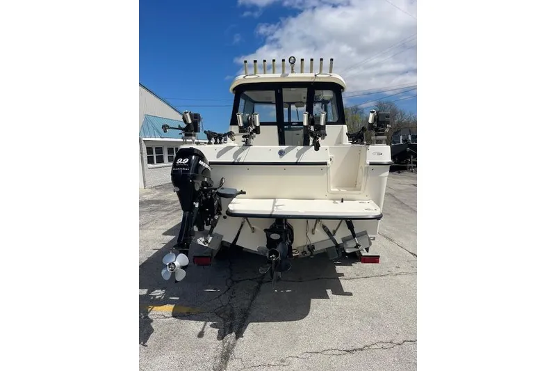 Slide: The Image of 2006 Trophy 2359 Hardtop boat, rear view with outboard motor, parked outdoors. - 18