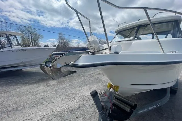 Slide: The Image of 2006 Trophy 2359 Hardtop boat on trailer, parked outdoors under cloudy sky. - 6