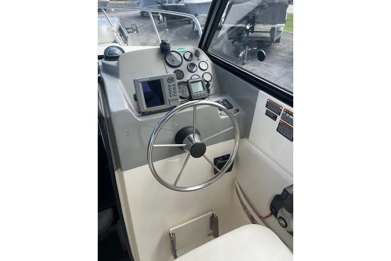 Slide: The Image of 2006 Trophy 2359 Hardtop boat helm with steering wheel and navigation instruments. - 8