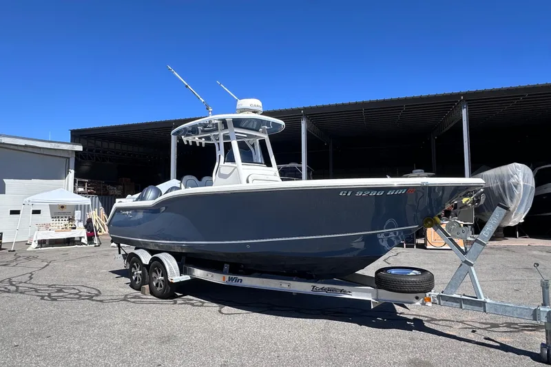 Slide: The Image of 2017 Tidewater 252 CC Adventure boat on trailer in sunny outdoor setting. - 1