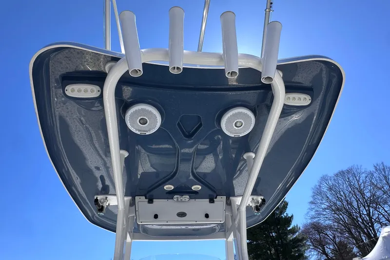 Slide: The Image of Tidewater 252 CC Adventure 2017 boat top view with rod holders and speakers against blue sky. - 11