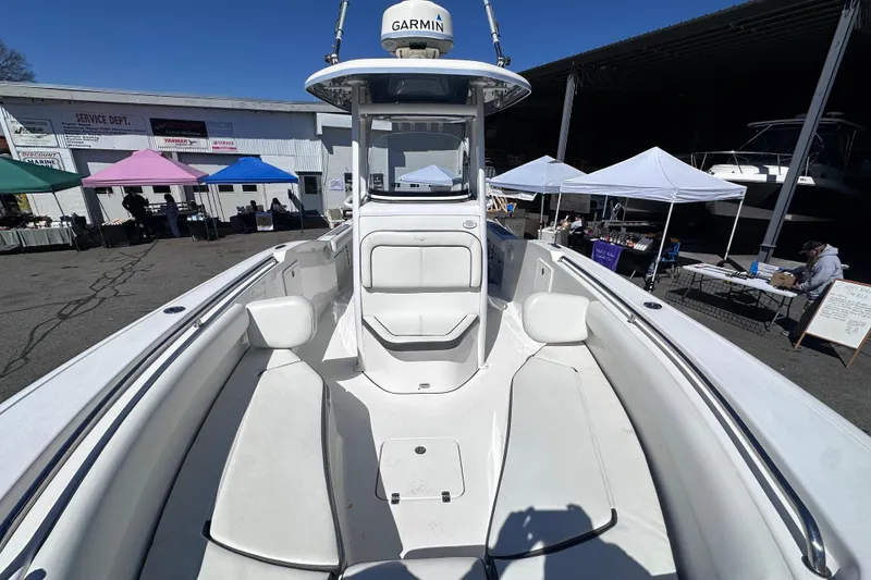 Slide: The Image of 2017 Tidewater 252 CC Adventure boat at a marina with colorful tents in the background. - 16