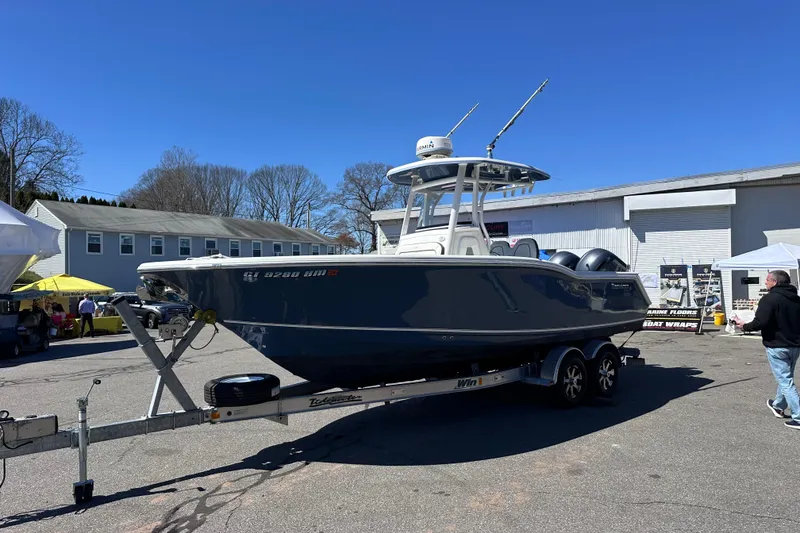 Slide: The Image of 2017 Tidewater 252 CC Adventure boat on trailer, displayed outdoors at a boat show. - 2