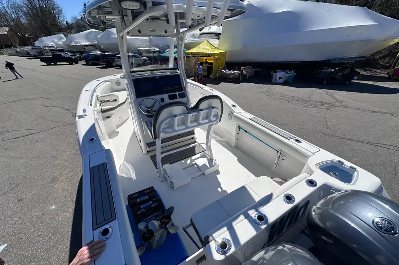 Slide: The Image of 2017 Tidewater 252 CC Adventure boat with center console and dual engines, parked outdoors. - 6