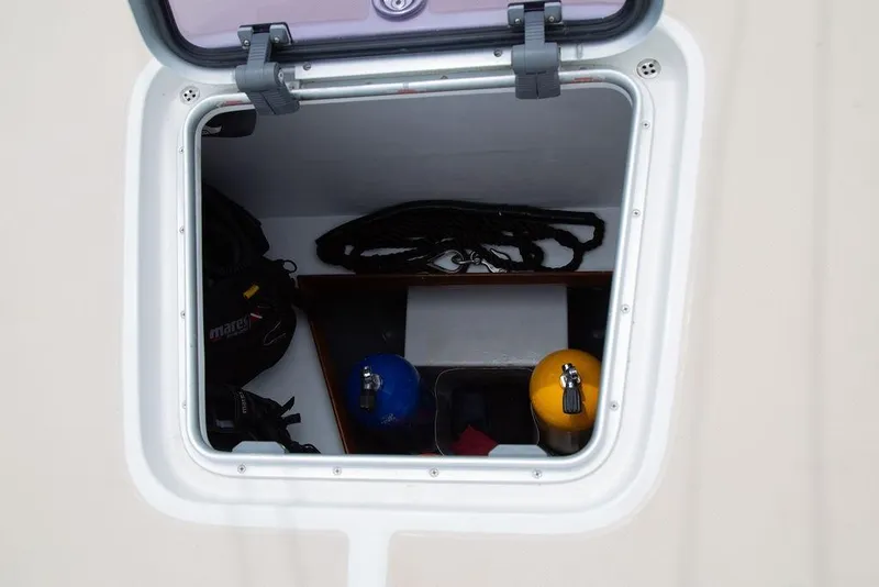 Slide: The Image of Open hatch on 2015 Outbound 46 sailboat showing storage with diving gear. - 103