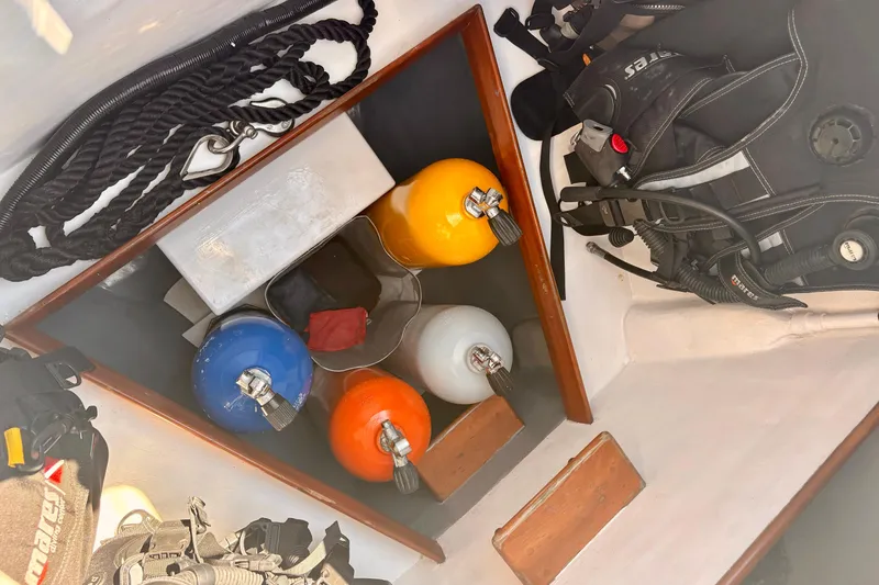 Slide: The Image of Diving equipment storage on 2015 Outbound 46 sailboat, featuring colorful air tanks and gear. - 104
