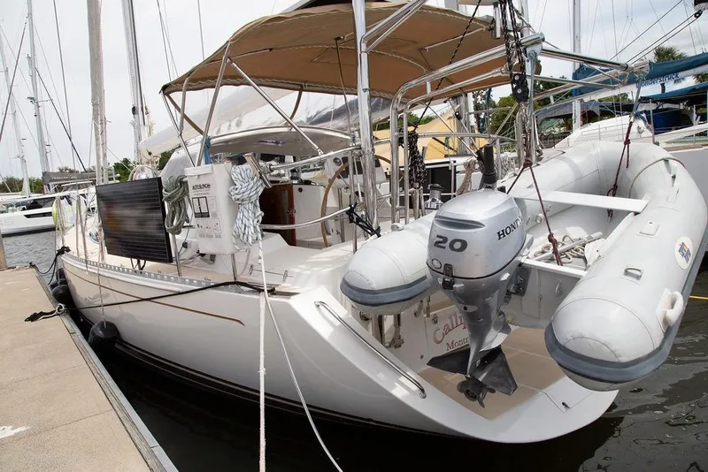 Slide: The Image of Outbound 46 sailboat from 2015 docked with inflatable dinghy and Honda outboard motor. - 13