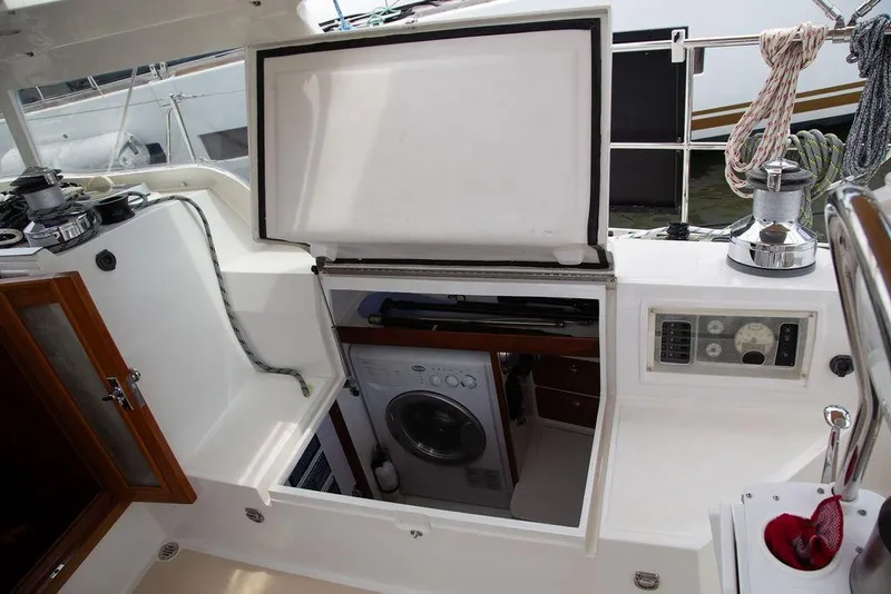 Slide: The Image of 2015 Outbound 46 yacht cockpit with open storage, washing machine, and control panel. - 19