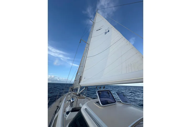 Slide: The Image of Sailing on a 2015 Outbound 46 yacht with white sails against a blue sky. - 2