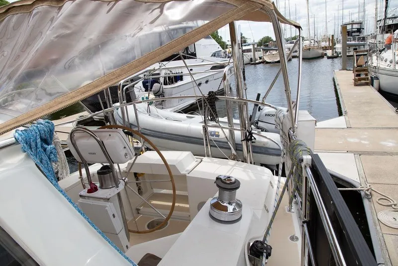 Slide: The Image of Cockpit of 2015 Outbound 46 yacht docked at marina with dinghy. - 23