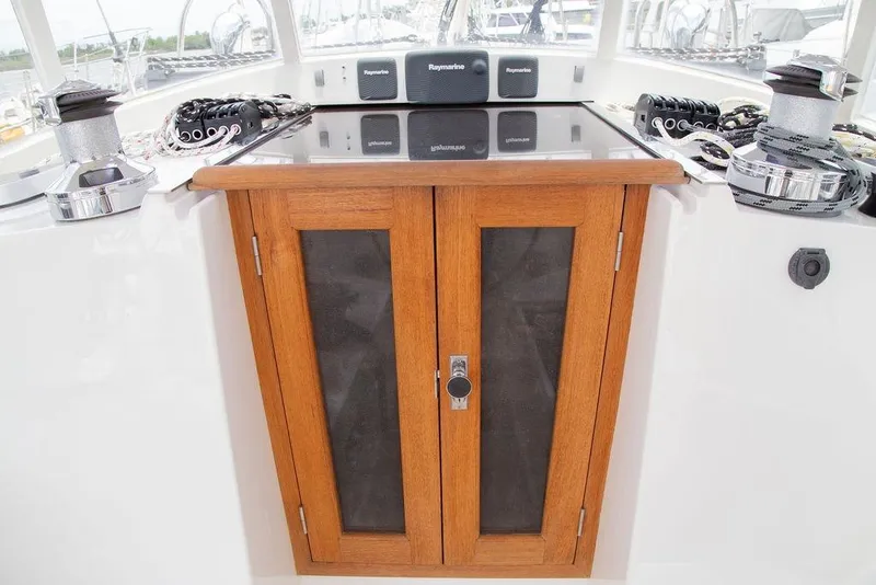 Slide: The Image of Wooden cabinet on Outbound 46 yacht deck, featuring navigation equipment and winches. - 28