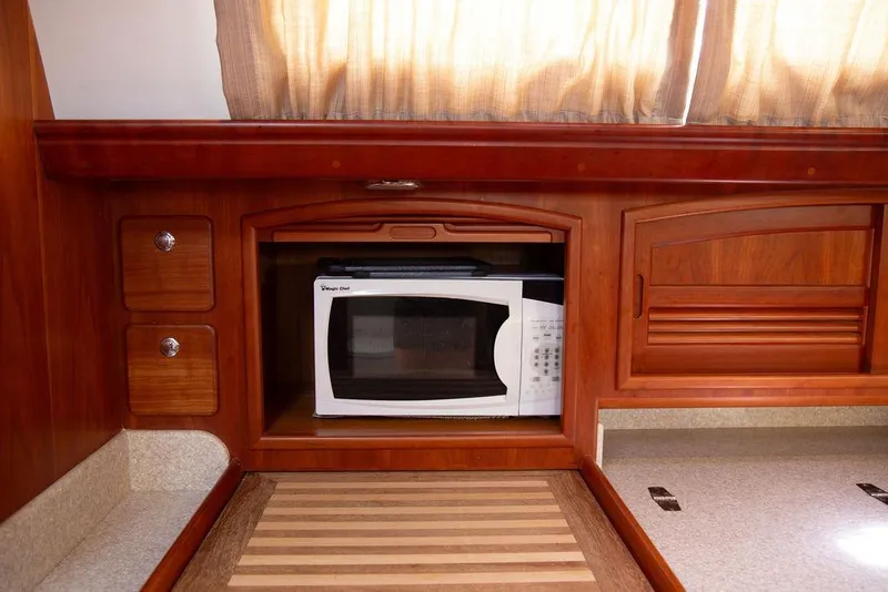 Slide: The Image of Wooden yacht kitchen with microwave, cabinets, and countertop. Outbound 46, 2015 model. - 37