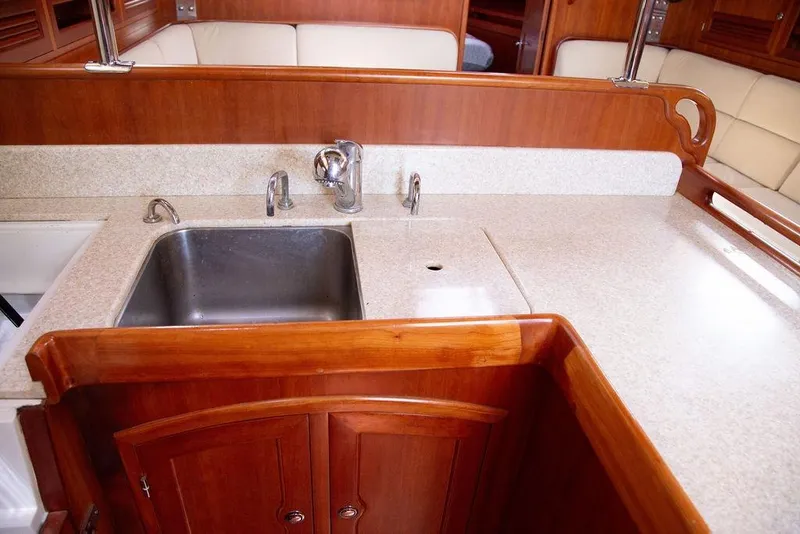 Slide: The Image of Luxurious 2015 Outbound 46 yacht interior with wooden cabinetry and modern kitchen sink. - 40