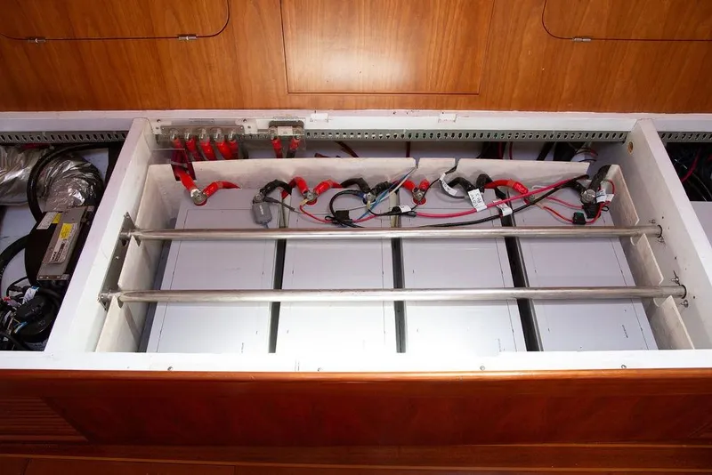 Slide: The Image of Battery compartment of a 2015 Outbound 46 yacht, featuring wiring and metal bars. - 44